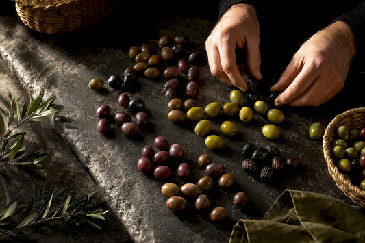 Siete tipos de aceitunas sobre una piedra oscura